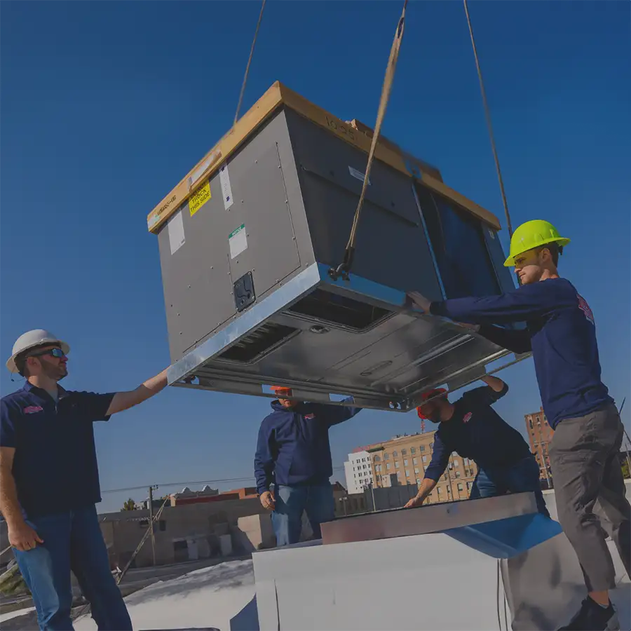 Rheem Pro Partners, group of technicians are moving large commercial cooling unit into place - commercial installation - Vandalia, IL